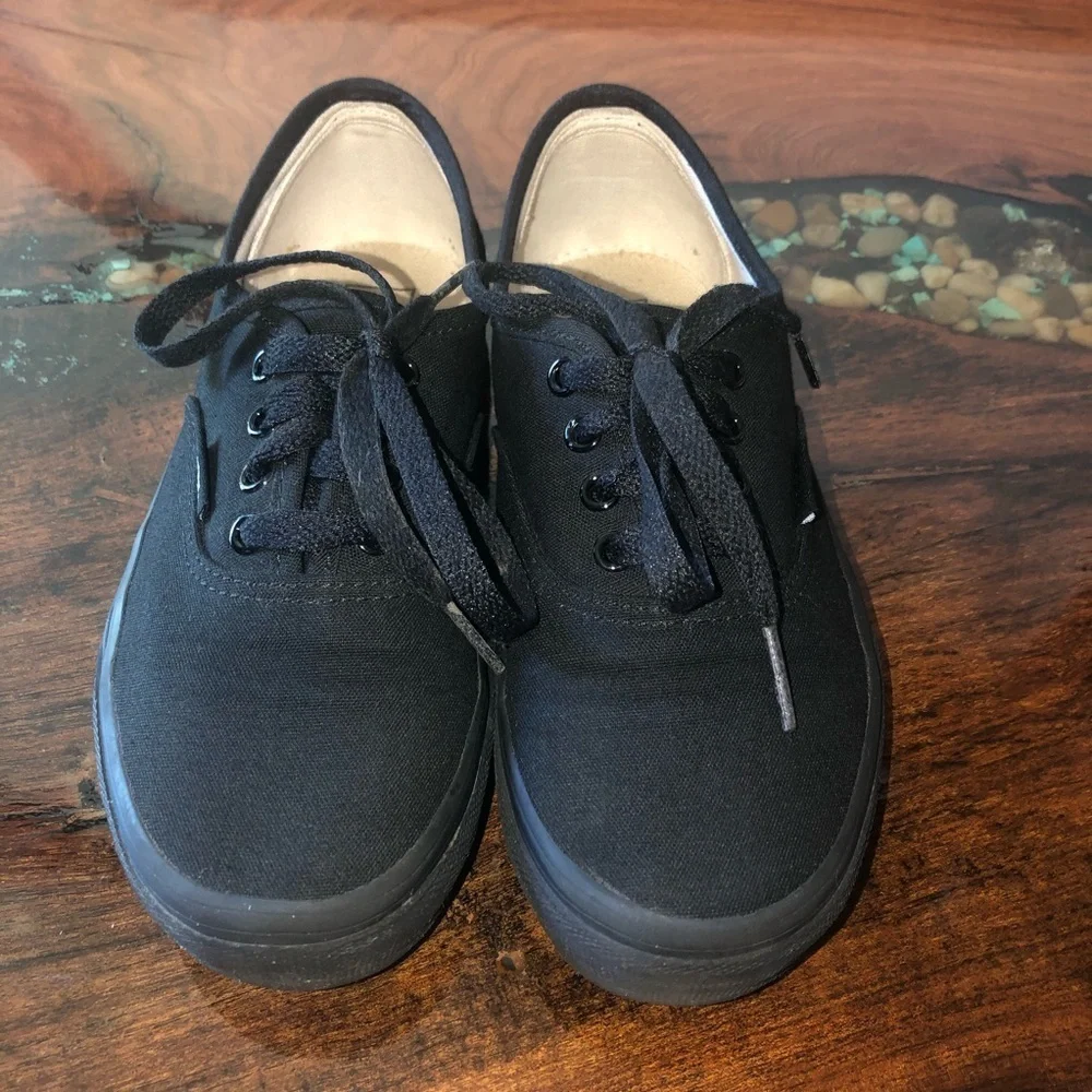 Vans all black kids lace up skateboard shoes.